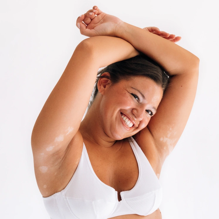 Smiling woman holding Inner Balance Oestra menopause cream jar