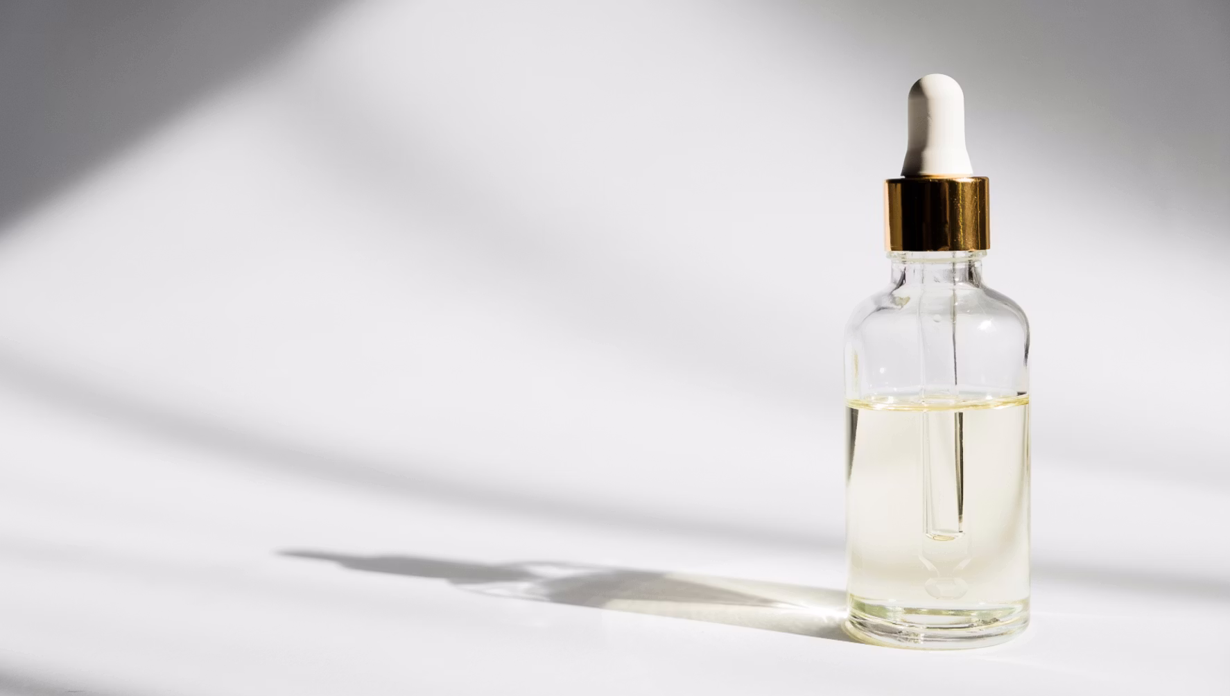 A glowing serum bottle on a clean white counter